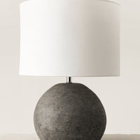 1: A table lamp with round black terracotta base and white cylinder shade.