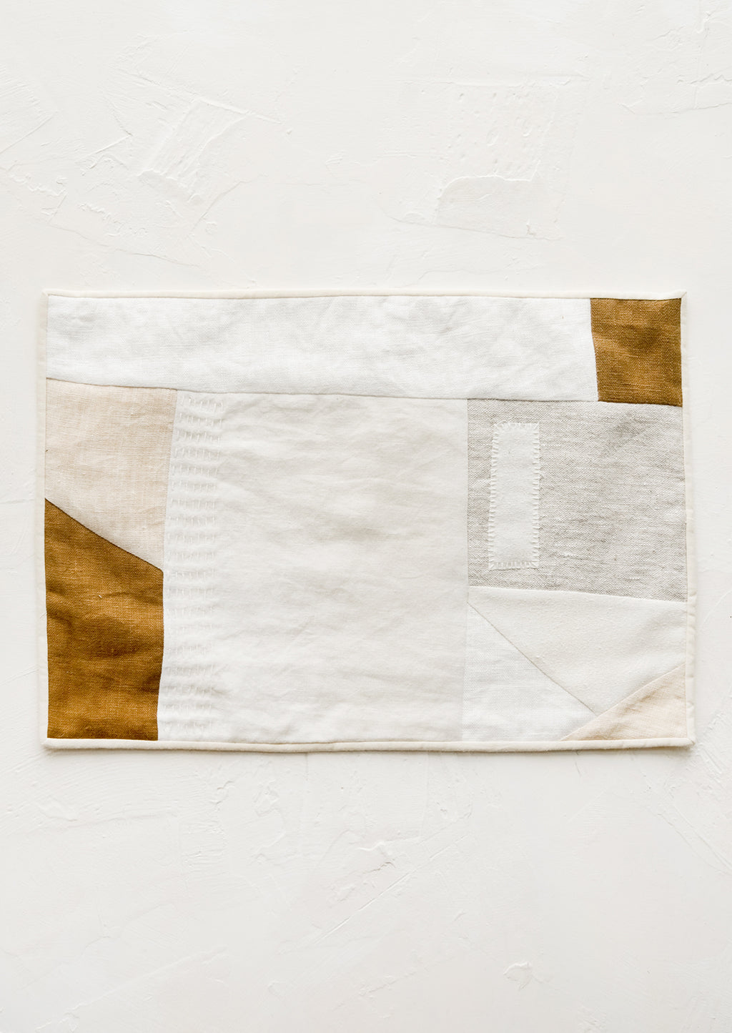 2: A rectangular placemat with patchwork design in natural shades.