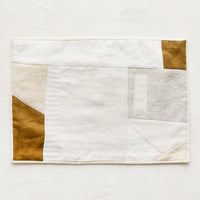 2: A rectangular placemat with patchwork design in natural shades.