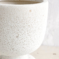 3: A planter in matte light grey textured glaze and footed urn shape.