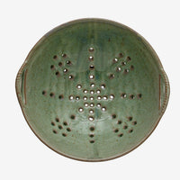 4: A large ceramic colander in mottled aqua glaze.