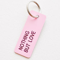 Nothing But Love: Small acrylic keychain, pink background with red words that says "NOTHING BUT LOVE"