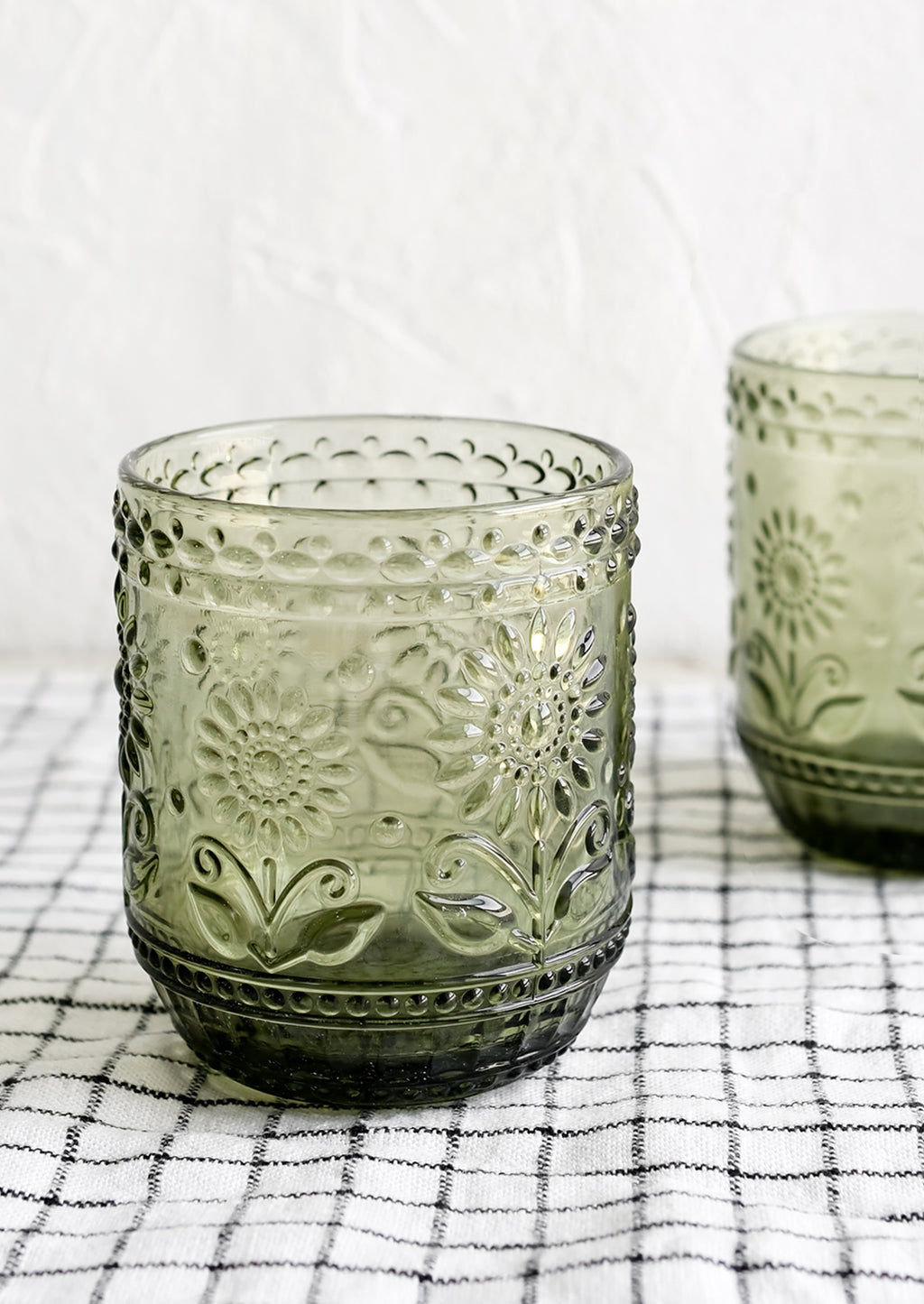 2: A pair of olive green glass tumblers with floral embossed motif.