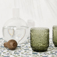 3: Olive green glasses pictured with a decanter holding water.