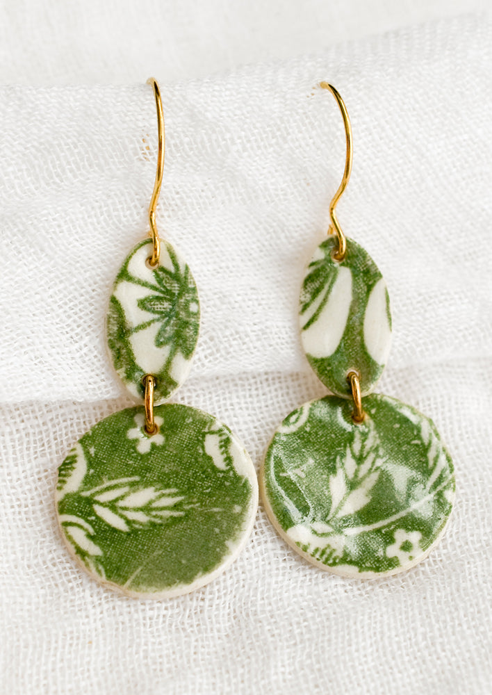 A pair of porcelain drop earrings with two lace imprint beads in green.