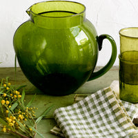 2: A green glass pitcher with large, rounded shape.