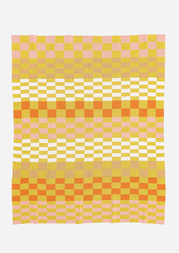 A knit throw blanket in checker print pattern in citron, tan ,white, pink and orange.