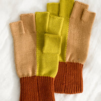 Citrine Colorblock: A pair of knit fingerless gloves in terracotta, peach and citrine colorblock.
