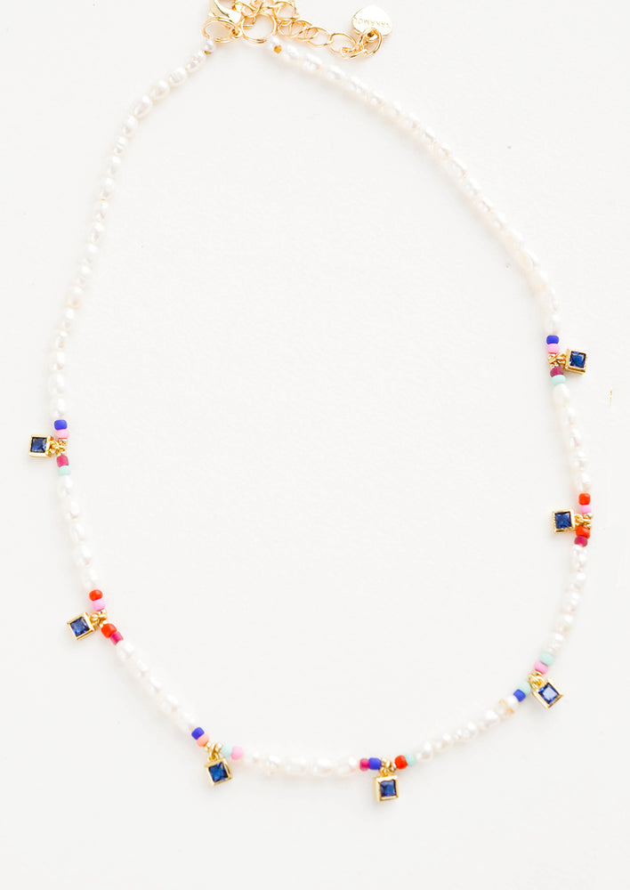 1: Beaded pearl necklace accented with square blue crystal stations and colored seed beads