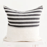 1: Square throw pillow with white and black striped top half and plain mudcloth bottom half