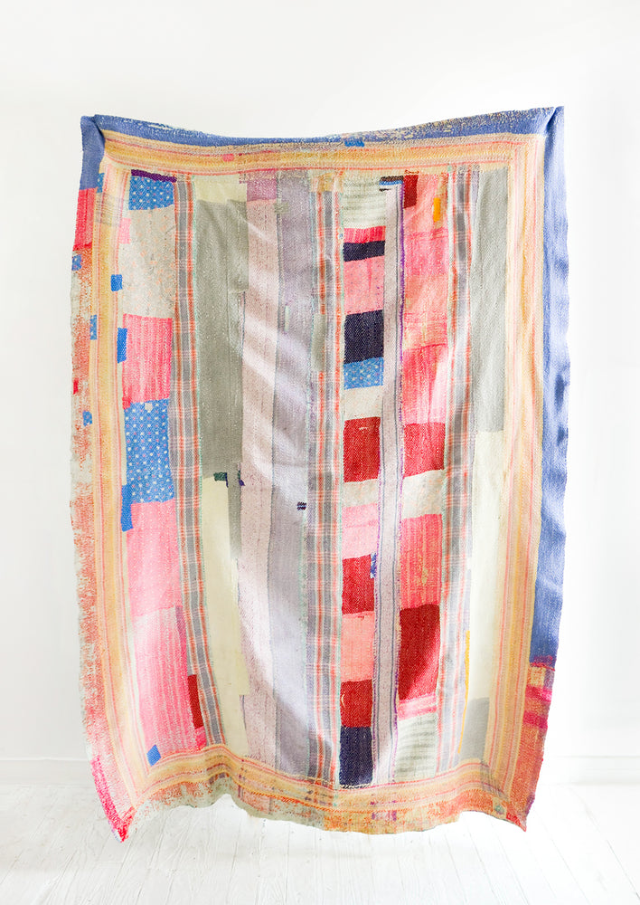 Vintage quilt with heavily patchworked design in blue, pink, red and various pastels
