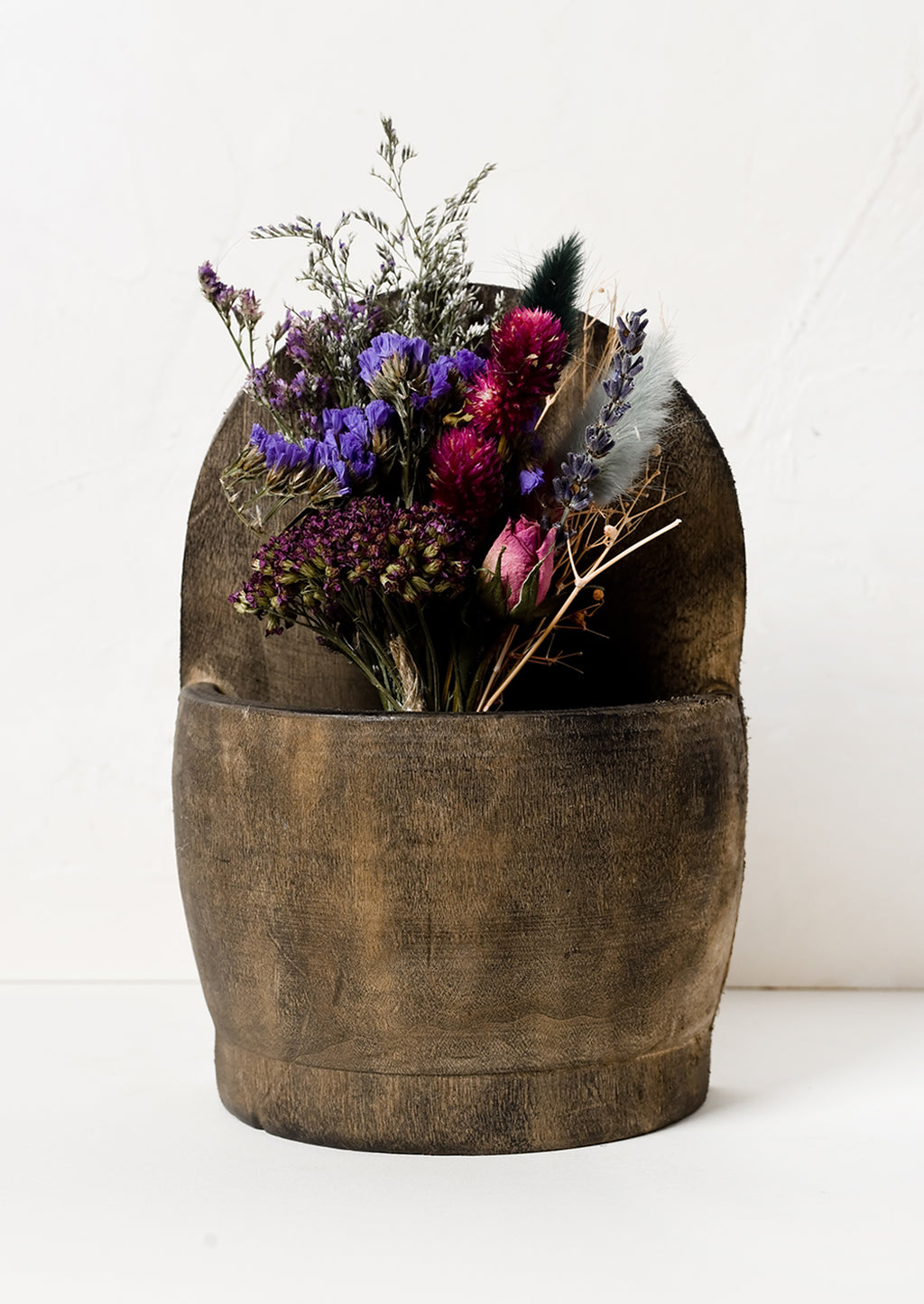 2: A wooden wall basket housing dried flowers.