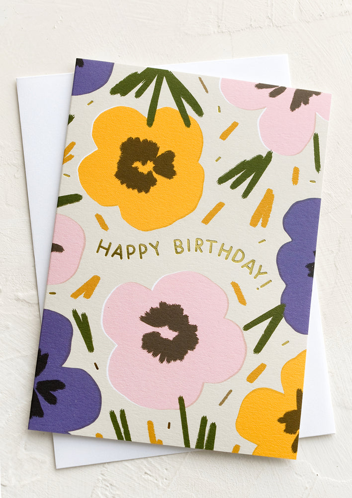 A floral print greeting card reading "Happy birthday"