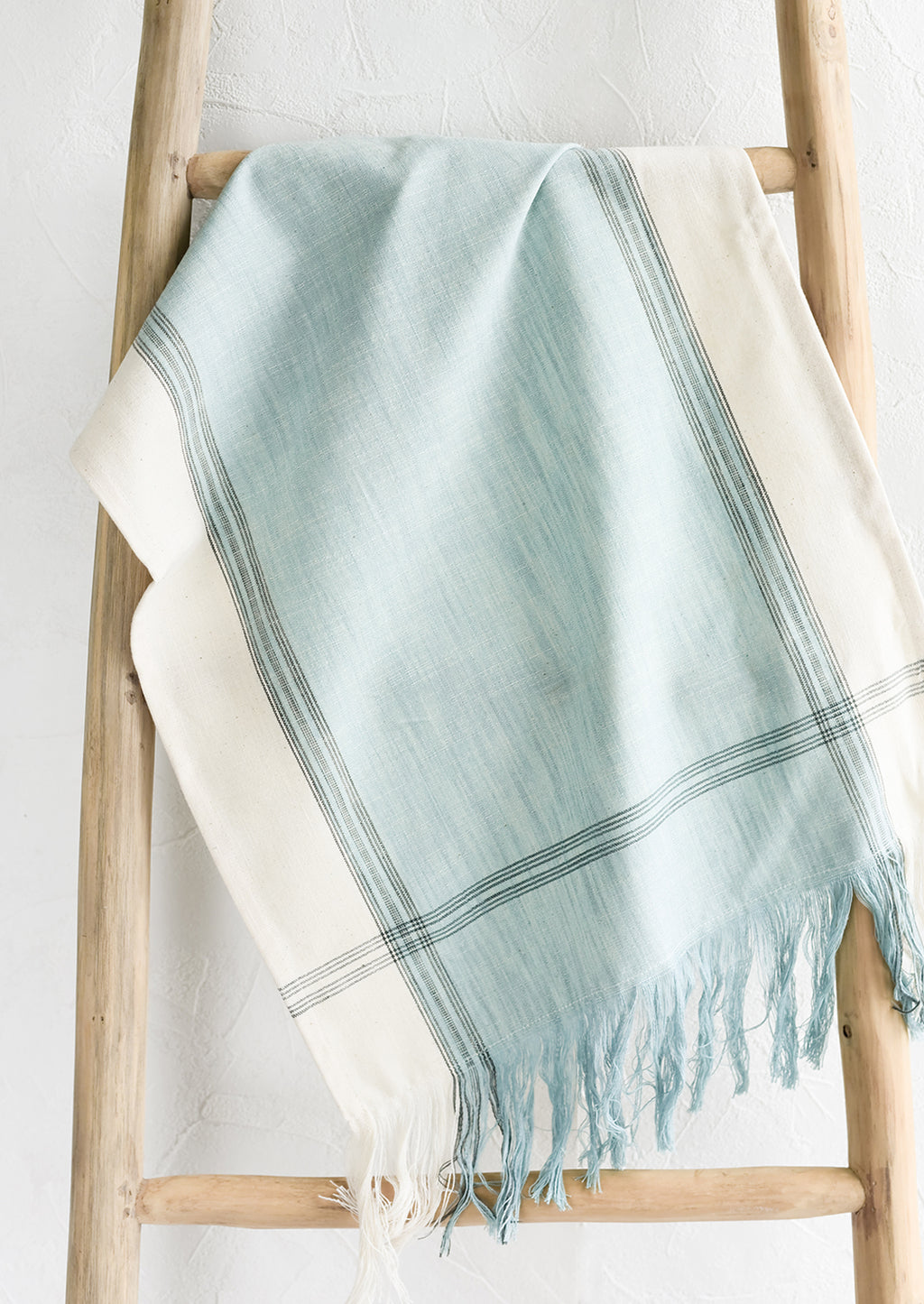 Chambray Blue: A blue cotton tea towel draped over a ladder.