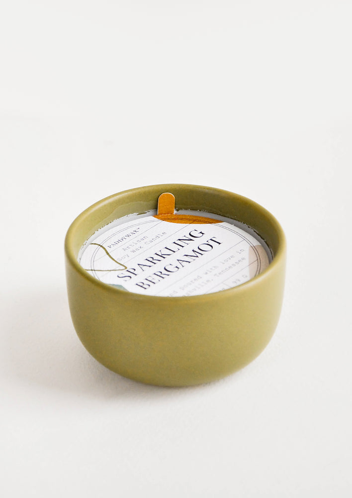 Small scented candle in colorful olive green ceramic vessel