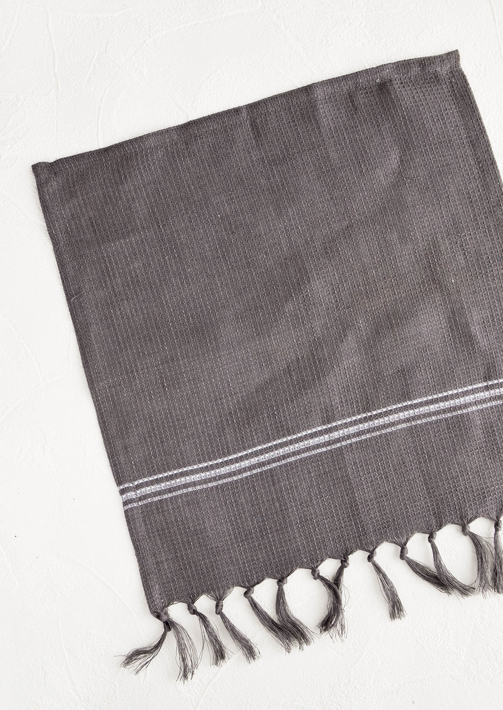 Charcoal: Waffle-textured dishcloths in charcoal color with single white stripe detail and tassel trim