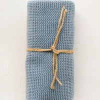 Wedgewood: A knit cotton dish towel in wedgewood blue, rolled and tied with twine.