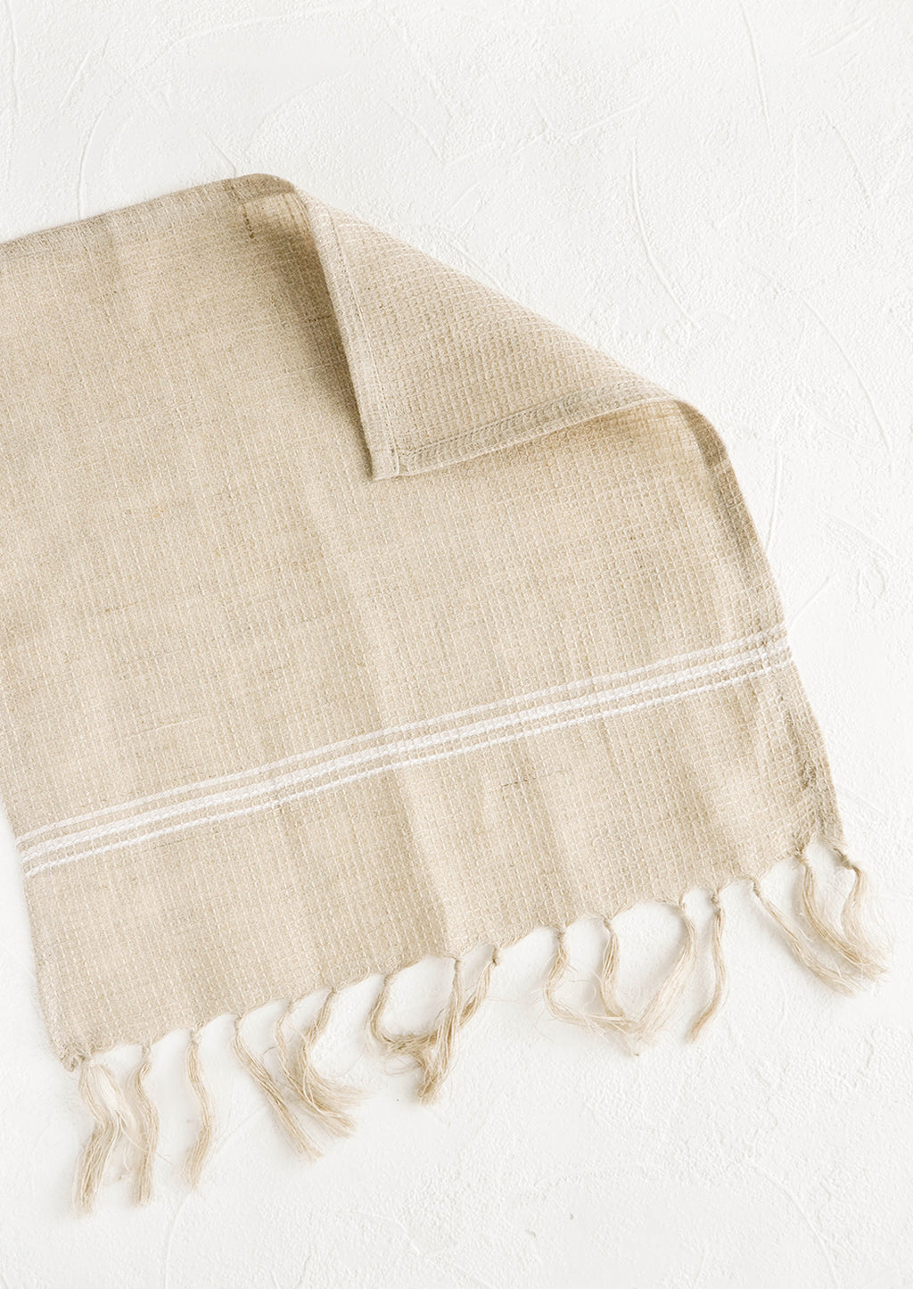 Natural: Waffle-textured dishcloths in natural color with single white stripe detail and tassel trim