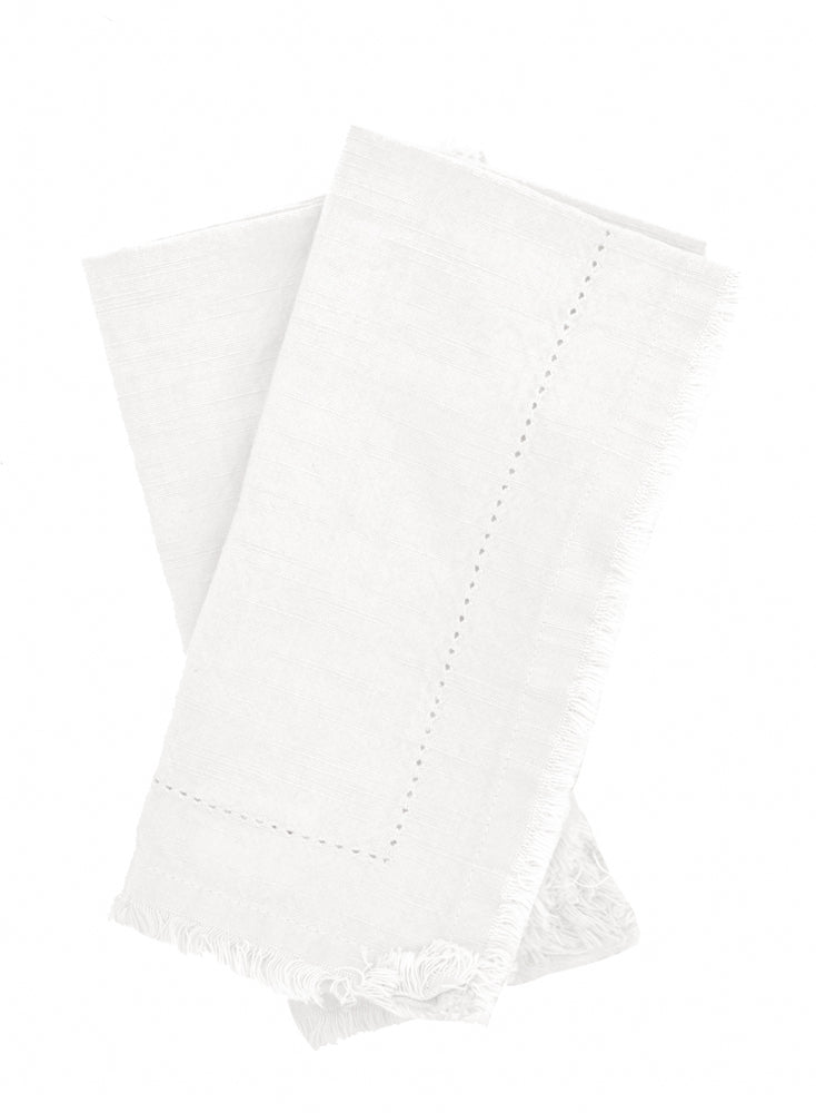Two folded ivory Cotton Napkins with frayed edges .