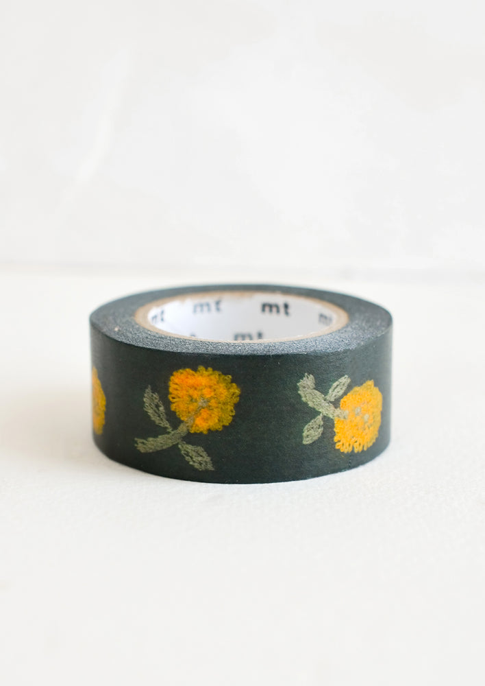 A roll of washi tape with dandelion print on black background.