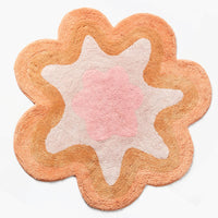 Pink / Caramel Multi: A wavy edge flower shaped bath mat in peach and pink.