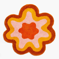 Rust / Orange Multi: A wavy edge flower shaped bath mat in rust and orange.