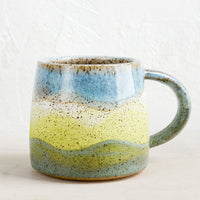 Blue Multi: A ceramic mug with handle in wavy stripe design in celadon, lime and blue.