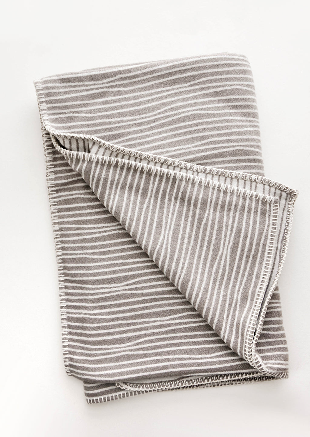Taupe / Ivory: Plush throw blanket with allover wavy lines print in white on taupe