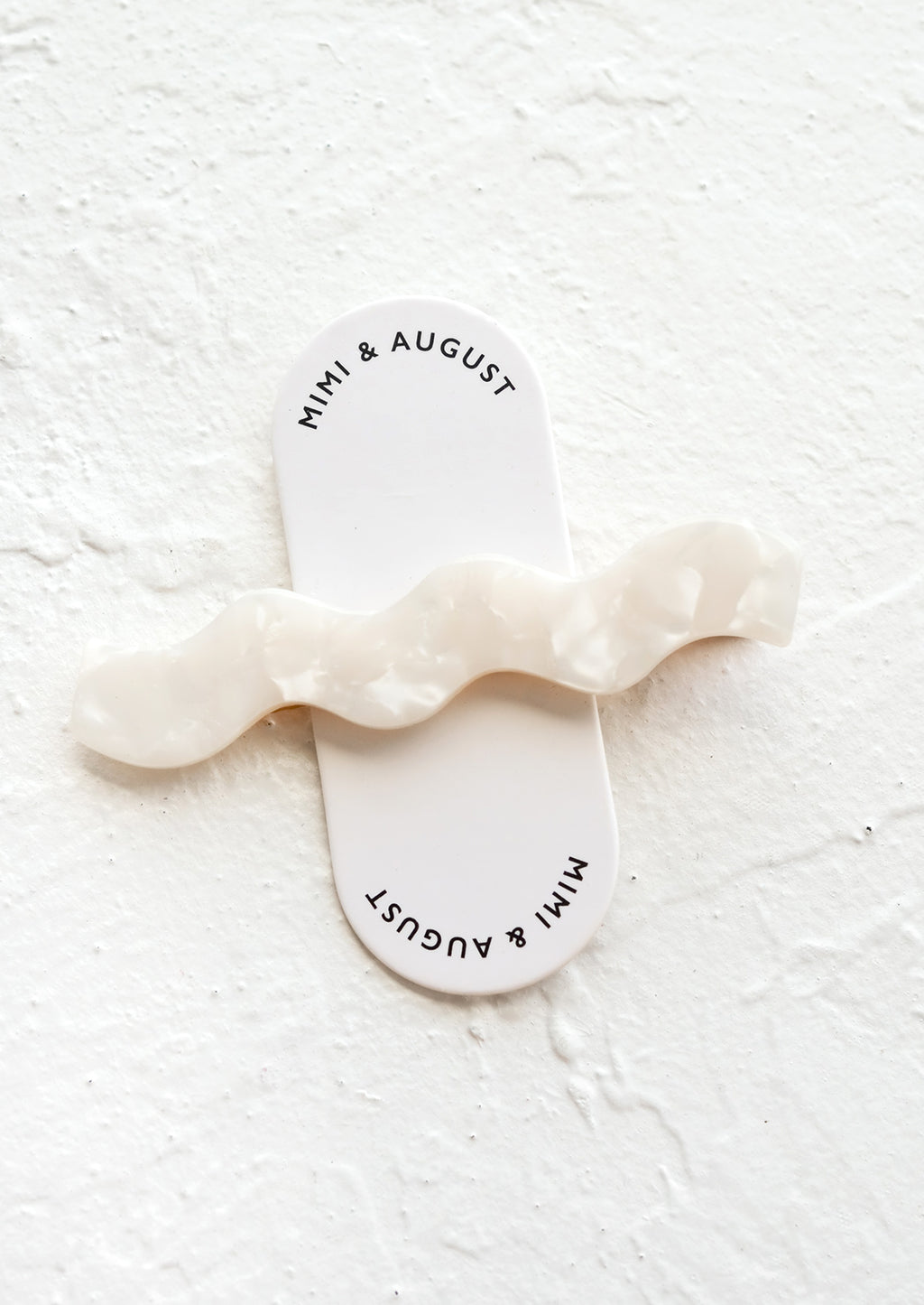 Pearl: White pearl hair clip with wavy squiggle shape.