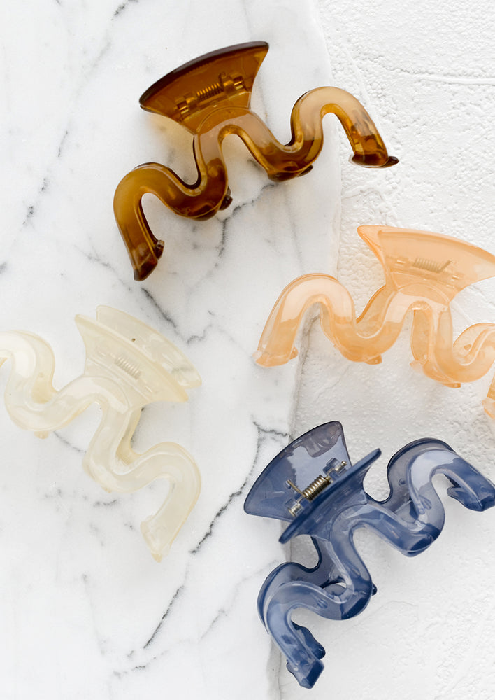 Assorted color hair clips in squiggle shape.