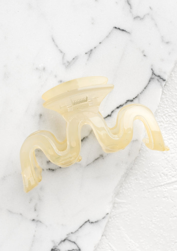 A wavy squiggle hair claw in pale banana.