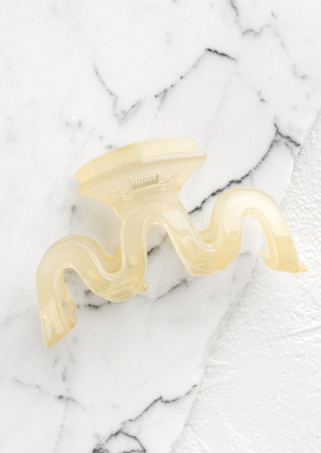 Pale Banana: A wavy squiggle hair claw in pale banana.