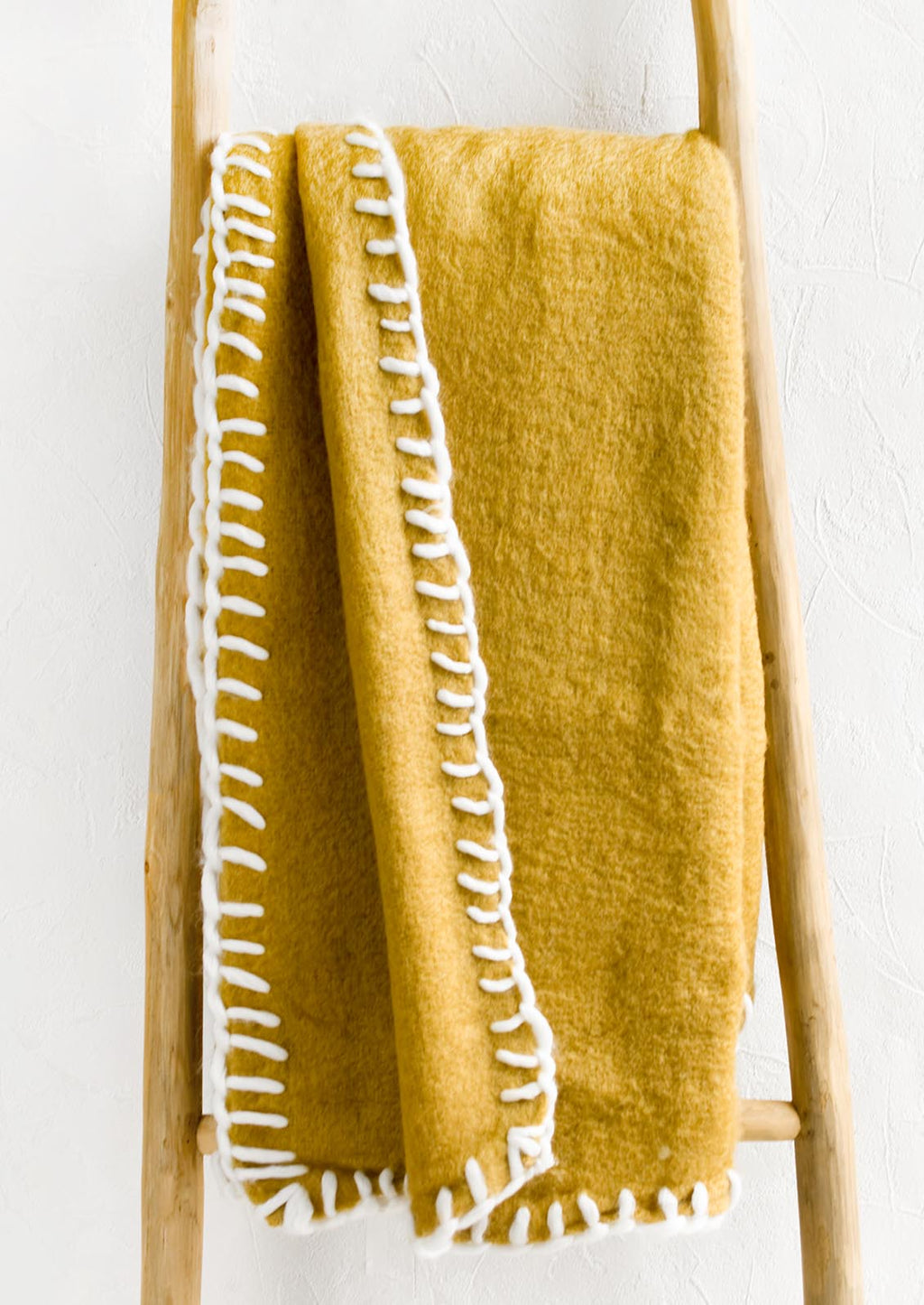 Mustard: A mustard mohair blanket with white yarn whipstitched trim.