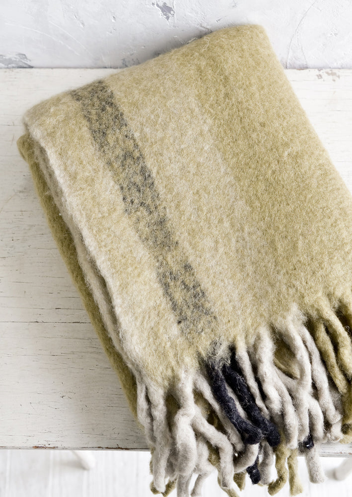 Ochre Multi: A fuzzy throw blanket with exaggerated fringe in ochre multi.