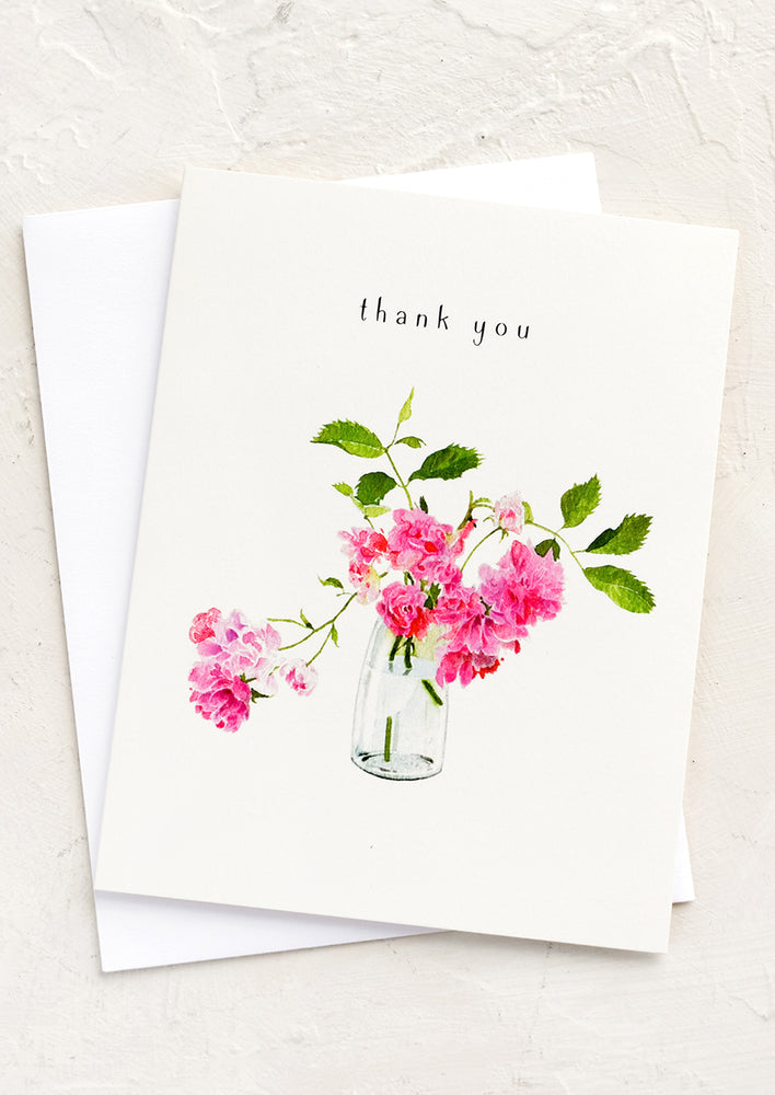 A greeting card with rose clippings in a vase, text above reads "thank you".