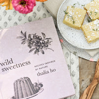 3: A cookbook pictured with flowers and lemon bars.