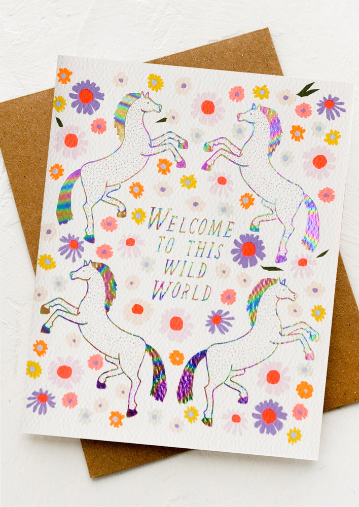1: A greeting card with unicorn floral print, text reads "Welcome to this wild world".