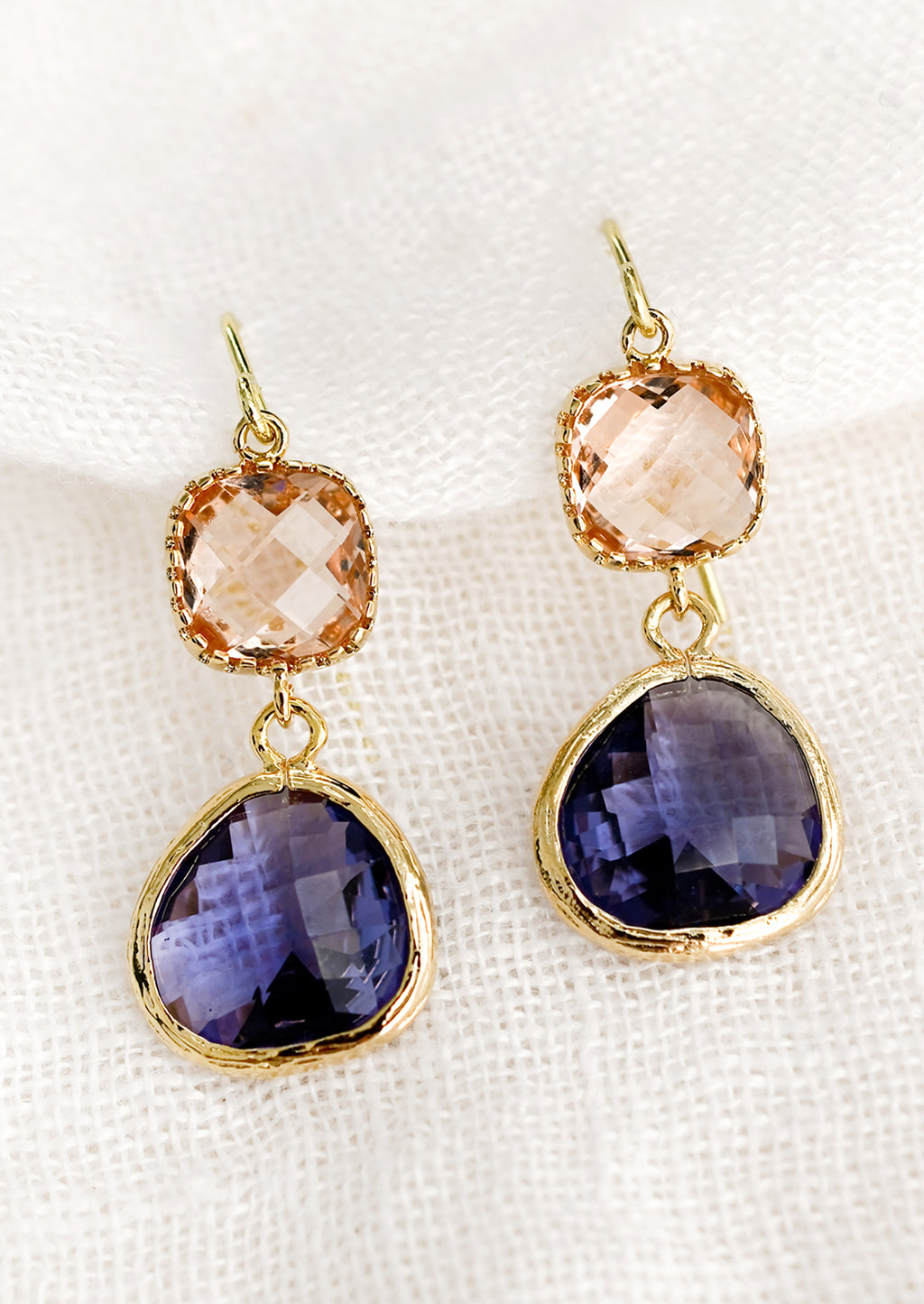 Peach / Tanzanite: A pair of two-stone bezeled gem earrings in peach and tanzanite.