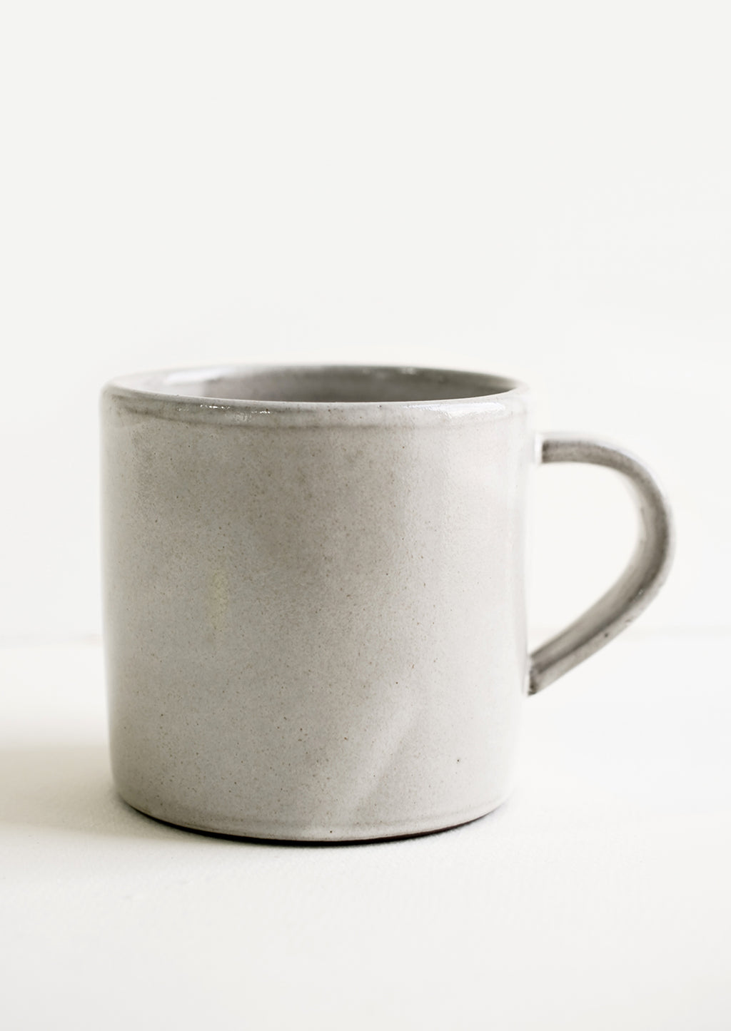 2: A ceramic coffee mug in a simple, classic shape in a white glaze over brown clay.