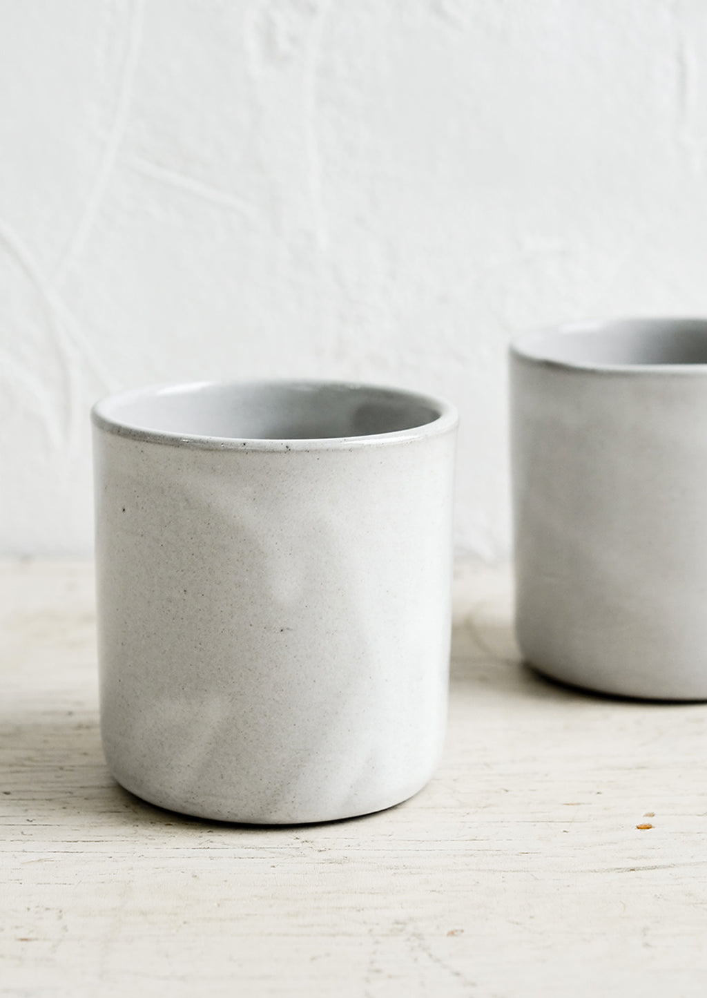 1: Two short ceramic cups in a grey glaze.
