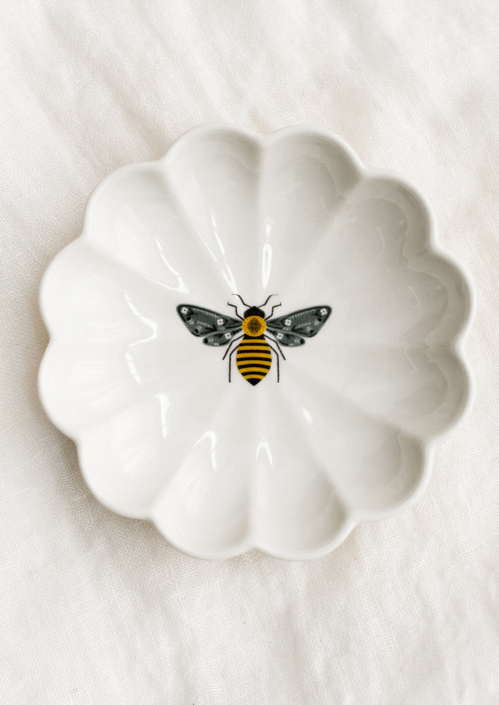 Bee: A white ceramic dish with scalloped shape and bee illustration at center.