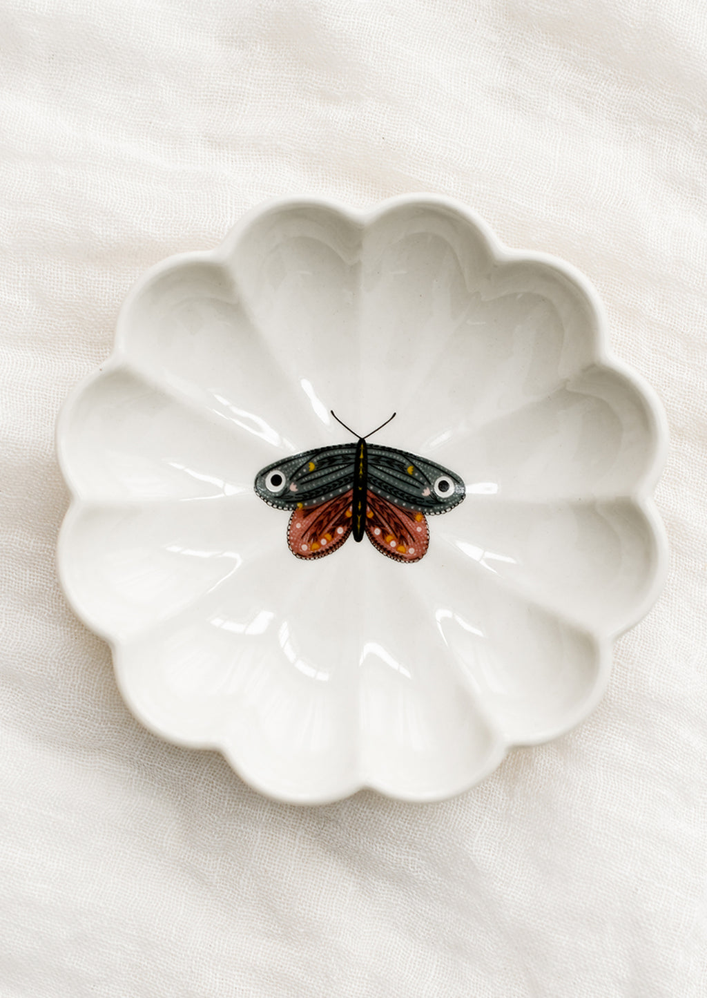 Dusty Blue Moth: A white ceramic dish with scalloped shape and pink and grey moth illustration at center.