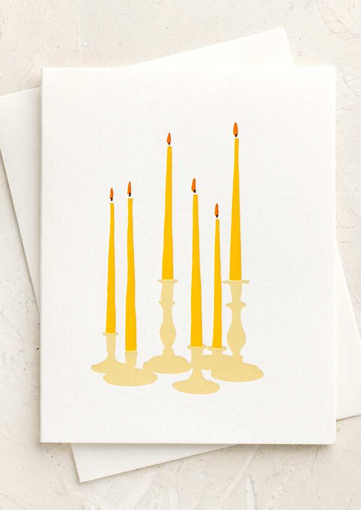 A letterpress printed card with lit candles.