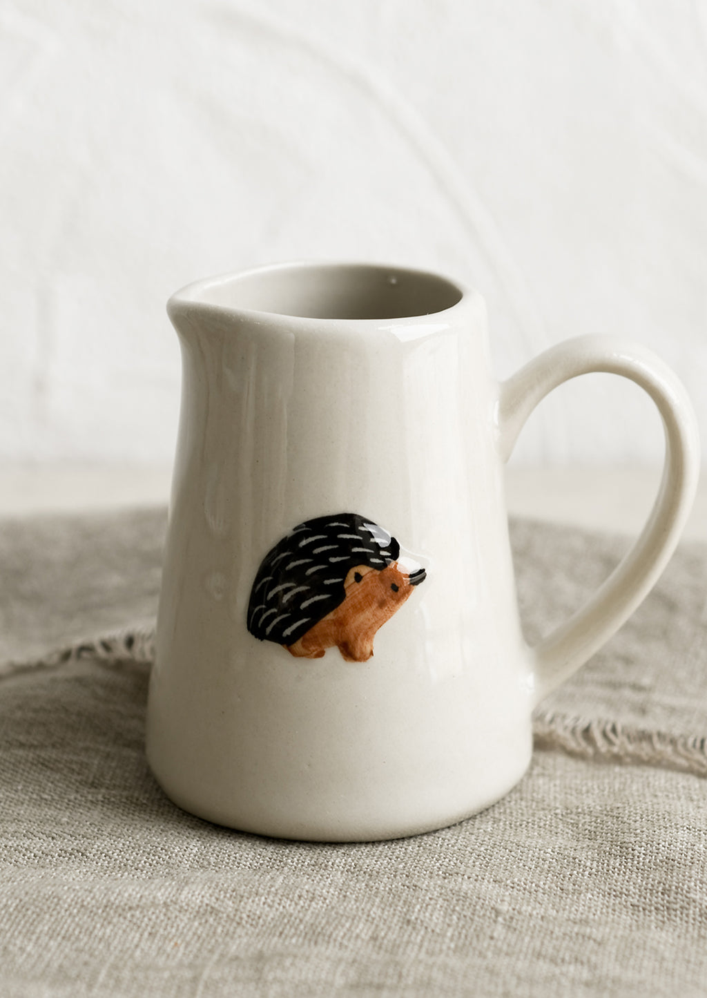 Porcupine: A small creamer pitcher in natural ivory with porcupine motif.