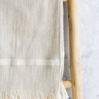 White Stripe: A woven kitchen towel with white stripe hanging on a ladder.
