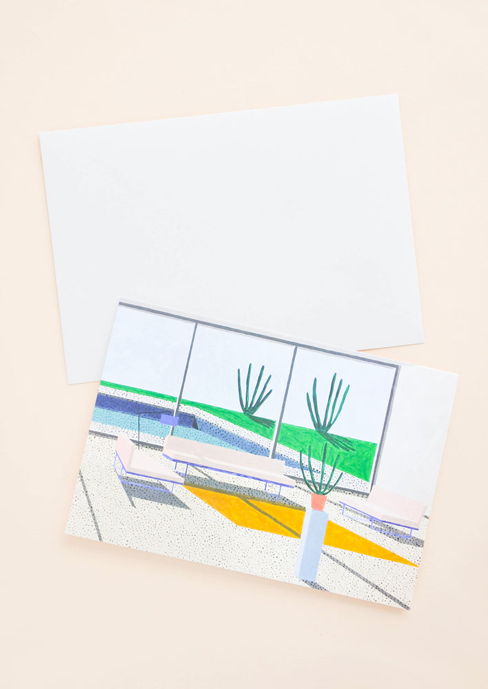 1: A white envelope and a greeting card of a colorful illustration of the interior of a modern desert house.