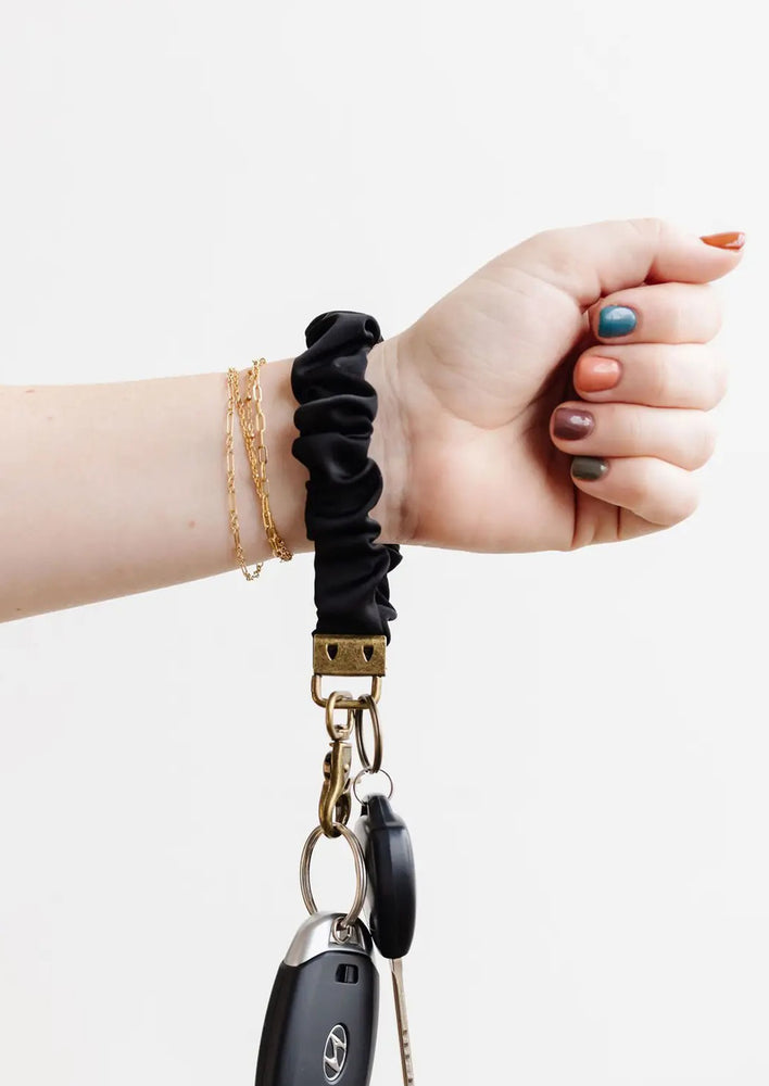 A woman with a black scrunchie keychain around her wrist.