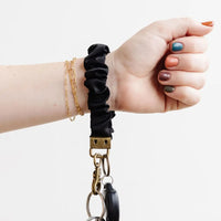 Black: A woman with a black scrunchie keychain around her wrist.