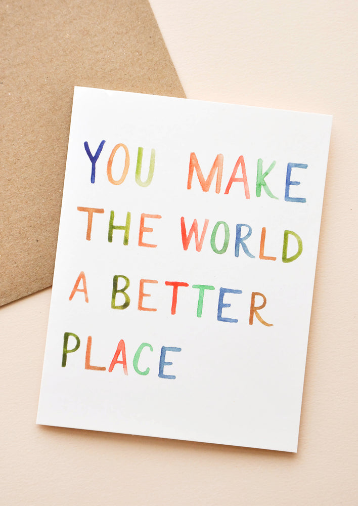 1: White notecard with rainbow painted text "You Make The World A Better Place Card" with brown envelope.
