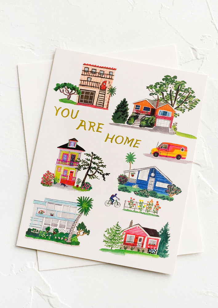A greeting card with illustrations of houses and text reading "You are home".
